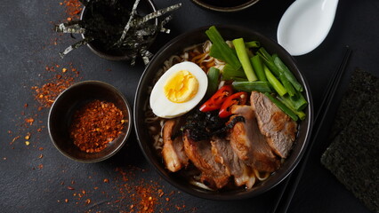 Ramen soup with hard boiled egg, vegetables, pork, soy sauce. Japanese tonkotsu ramen, pork bone broth noodles