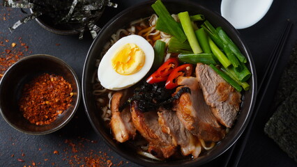 Ramen soup with hard boiled egg, vegetables, pork, soy sauce. Japanese tonkotsu ramen, pork bone broth noodles