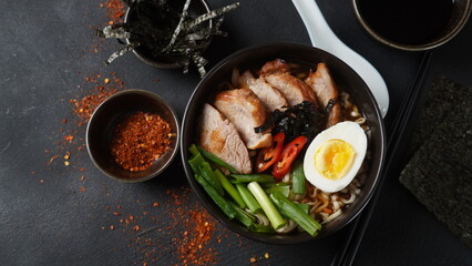 Ramen soup with hard boiled egg, vegetables, pork, soy sauce. Japanese tonkotsu ramen, pork bone broth noodles