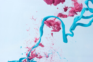 Abstract blue and pink ink drop over gray background