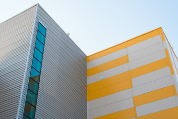 Exterior of non-residential new industrial building made of gray and yellow sandwich panels with...