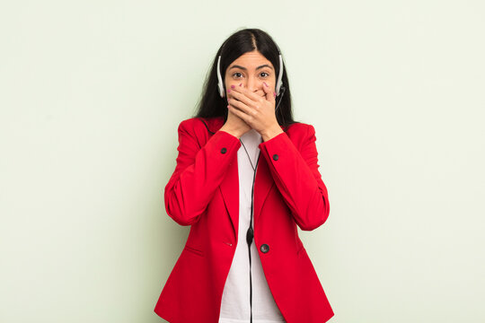 young pretty hispanic woman covering mouth with hands with a shocked. telemarteker concpet