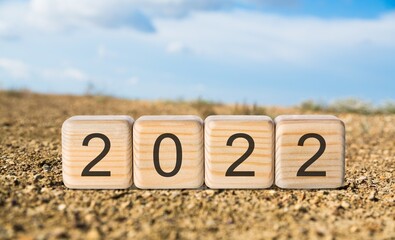 Happy New Year 2022 on wood cube block and nature background