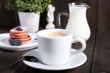 Cafe espresso macchiato layered coffee in a see through white glass coffee cup.