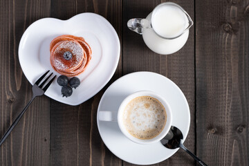 Cafe espresso macchiato layered coffee in a see through white glass coffee cup.