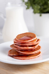 Stack of breakfast pancakes with jam raspberry on light background