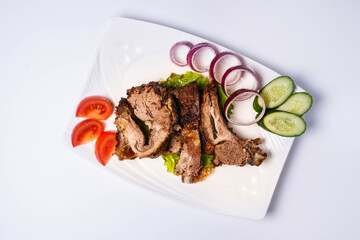 roast lamb with fresh tomatoes and cucumbers. on a white background