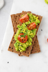 Sandwich with avocado guacamole on light board. Close up