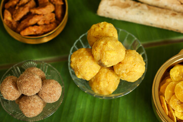 Onam special snacks like laddu banana chips, sweet chips, fried snacks in Kerala India. Indian cookies on a plate