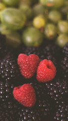 Summer fruity berry background. Table with berries and fruits. Summer breakfast, vacation, morning, sun. Berries, raspberries, blackberries, gooseberries. Vase with berries and fruits. 