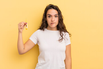 young pretty hispanic woman looking puzzled and confused. thermometer concept