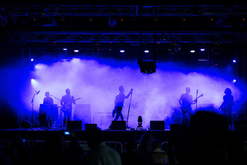 Fototapeta na wymiar Rock group performing before the audience at a live concert.