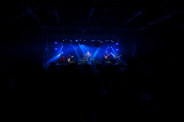 Fototapeta na wymiar Rock group performing before the audience at a live concert.