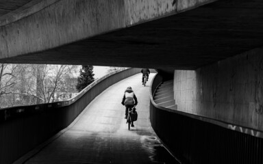 person cycling on bridge in tunnel