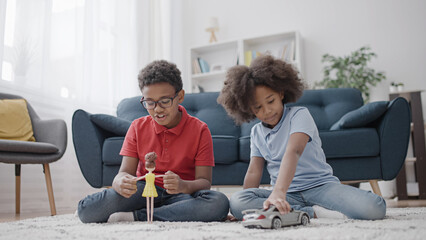 Curious little boy playing with a doll and his sister playing with a toy car, gender stereotypes in toys