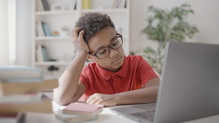 Sad school pupil sitting in front of laptop, problems of distance learning