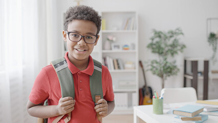 Portrait of smiling African American boy with backpack, first day of school