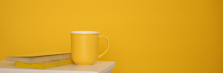 Mug jaune sur fond jaune avec livres et espace vide pour texte - mock up pour texte ou design
