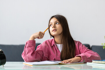 Young school girl thinking while make homework