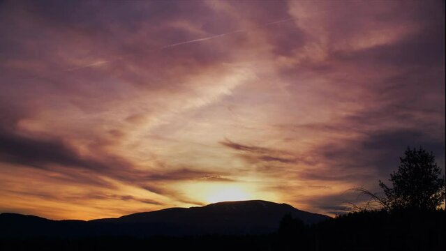 Heavenly golden sunset timelapse over a natural mountain backdrop.