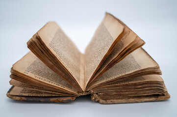 An Old Book Is Lying Flat On Both Covers Displaying A Bouquet Of Pages Opened And Forming A Half Circle Within The Frame. Words are legible from the tops of the pages.