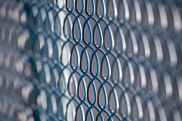 Frost Link Fence Viewed Close Up. The focus is on the links in the center of the image. Both the right and left sides of the image blur slightly towards the outer edges.