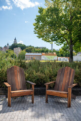 Two Wooden Outdoor Chairs Sit Empty Along The Boardwalk Beside The Marina In The Ports Area Of Quebec City.