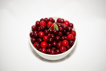 white plate with red cherry on light background