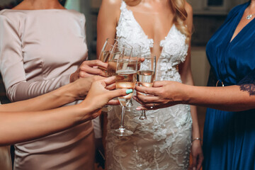 toast. girls clink glasses of champagne. without faces. wedding