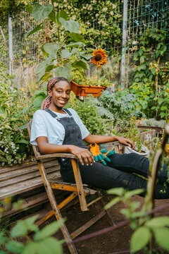 Portrait of female environmentalist sitting on chair in community garden