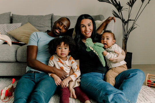 Portrait of smiling multiracial family in living room