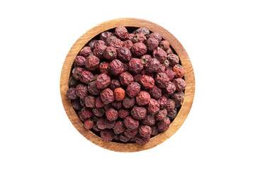 dried hawthorn berries in wooden bowl isolated on white background. Vegan food, top view.