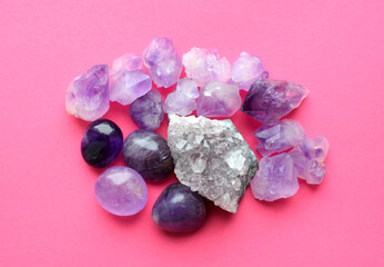 Beautiful gemstones,  geode of  amethyst and druses of natural purple mineral amethyst on a bright pink background. Amethysts and rose quartz. Large crystals of semi-precious stones.