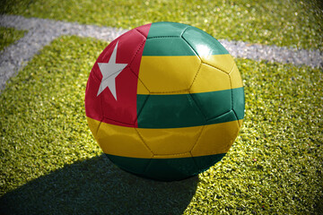 football ball with the national flag of togo lies on the green field