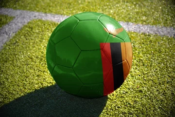 Foto op Aluminium football ball with the national flag of zambia lies on the green field © luzitanija