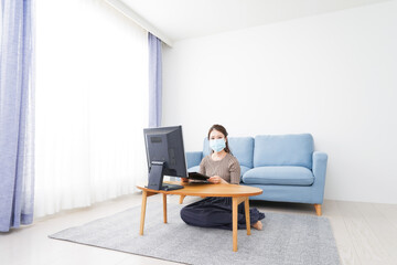 Fototapeta premium マスクをしてオンライン会議に参加する若いビジネスウーマン