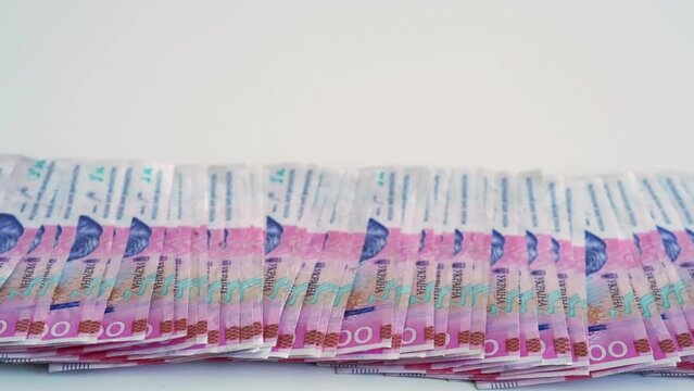 Money background. Ukrainian hryvnia. UAH foreign currency. 200 hrn bill pink blue paper banknotes cash pile isolated on white copy space.