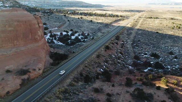 DRONE FOLLOWING WHITE CAR IN MOAB UTAH WITH MOUNTAINS AND SNOW ON ROADTRIP.
4k 60 FPS DJI AIR2S
