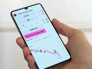 Stock exchange etf market chart down, bear market nft data on smartphone. (Exchange-traded fund). Business analysis of ETF play to earn NFT