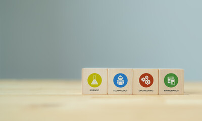 STEM concept. Science, technology, engineering, mathematics education..Education trend to solve a problems for innovation, high value product.  Wooden cubes with colorful STEM icons on grey background