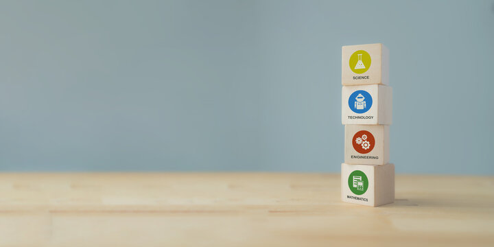 STEM concept. Science, technology, engineering, mathematics education. Education trend to solve a problems for innovation, high value product.  Wooden cubes with colorful STEM icons on grey background