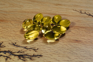 Fish fat cod liver oil omega gel capsules on wooden background