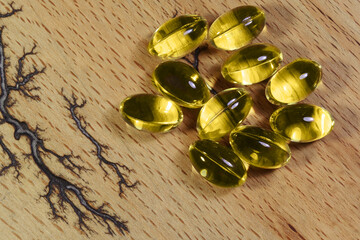 Fish fat cod liver oil omega gel capsules on wooden background