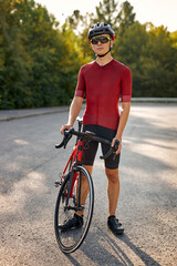 portrait of sporty young man with protective helmet posing on nature background. handsome caucasian Male athlete in sportswear preparing before the riding the bike in mountain.