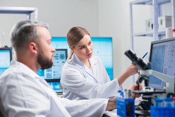 Fototapeta premium Professional team of scientists is working on a vaccine in a modern scientific research laboratory. Genetic engineer workplace. Future technology and science.