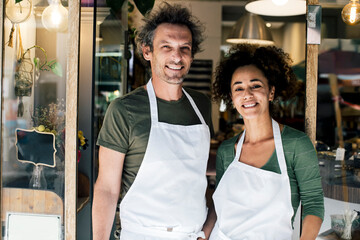 Portrait of male and female owners against bakery