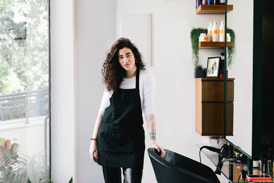 Portrait of female owner standing in hair salon