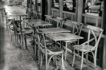 tables and chairs on the street - vintage black and white - 484188154