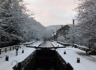 winter scene on the rochdale canal in hebden bridge with snow covered towpath and houses - Powered by Adobe