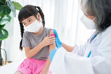 Doctor is affixing the medicinal plaster after vaccinated in shoulder of Asian girl kids in...